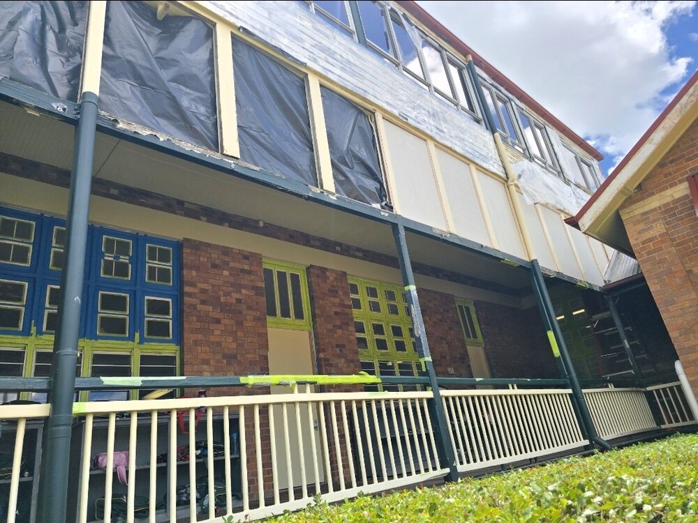 A building wrapped in containment sheeting during a licensed asbestos removal